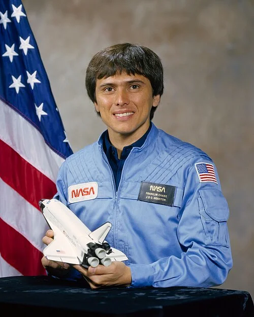 Franklin Chang Díaz in his official NASA astronaut portrait holding a Space Shuttle model
