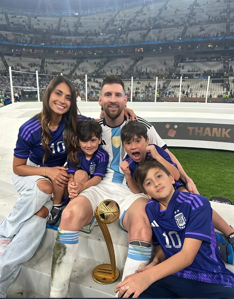 Lionel Messi with his wife and three sons after winning the 2022 World Cup, holding the Golden Ball trophy