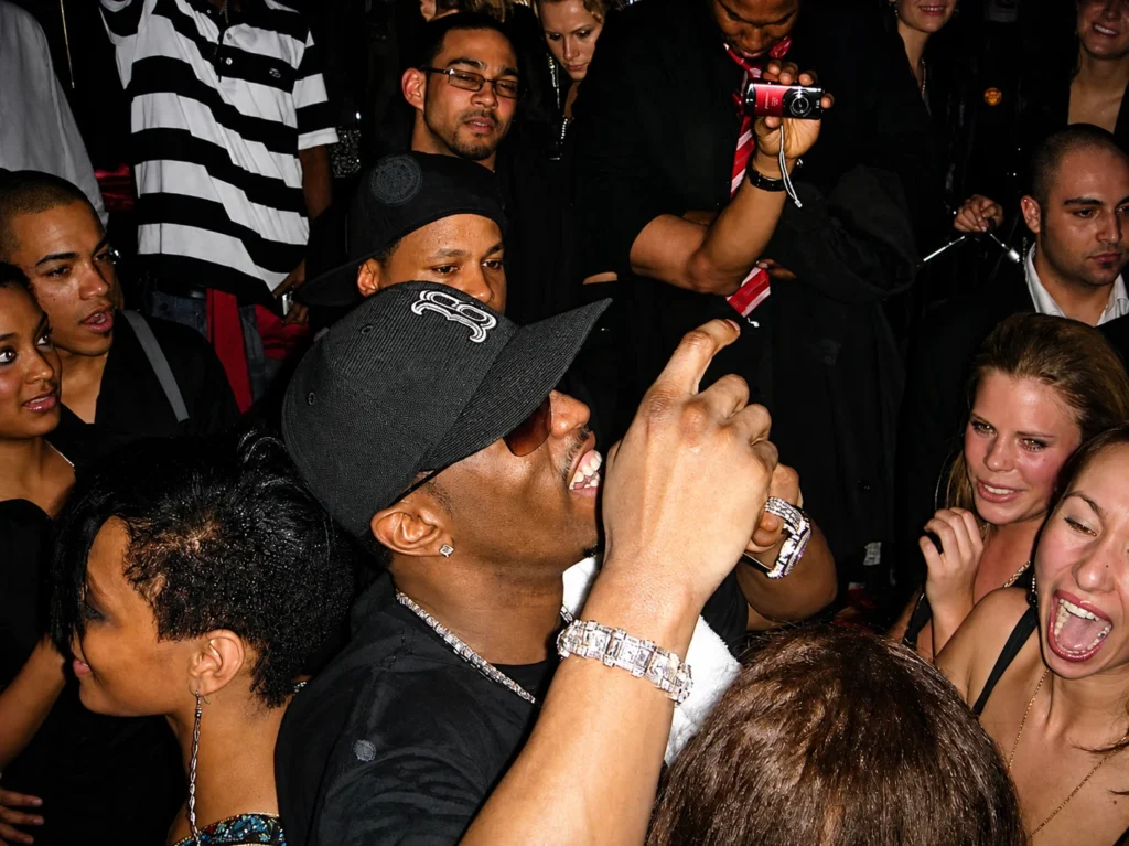 Sean Diddy Combs at nightclub party surrounded by crowd wearing diamond jewelry
