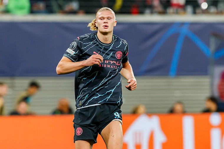 Erling Haaland running in Manchester City's black lightning-pattern away kit during a match