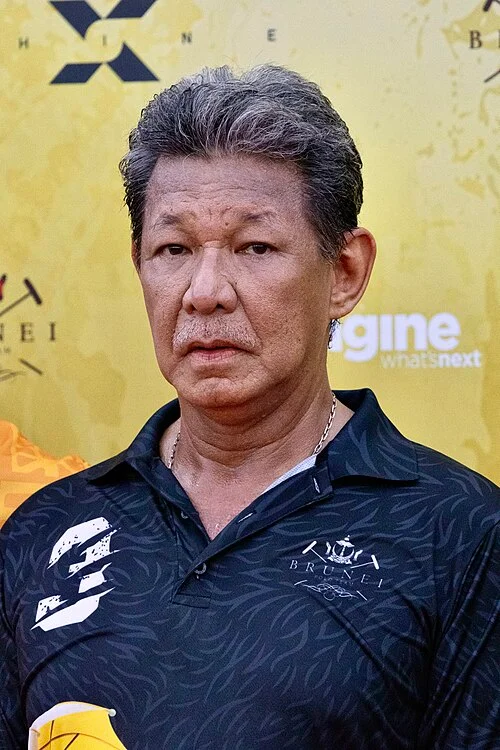 Prince Jefri Bolkiah, former Finance Minister of Brunei, wearing a dark Brunei polo shirt at a public event