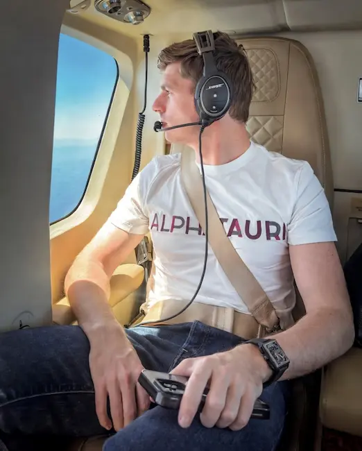 Max Verstappen in AlphaTauri t-shirt and headset inside a helicopter during race-weekend travel
