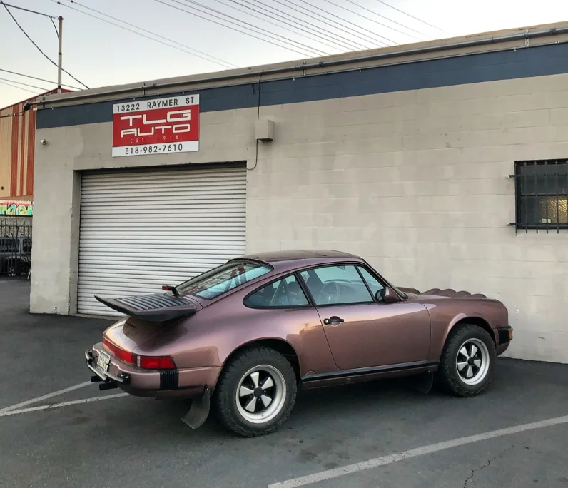 Matt Farah's modified 1987 Porsche Safari 911 Keen Project parked outside a shop