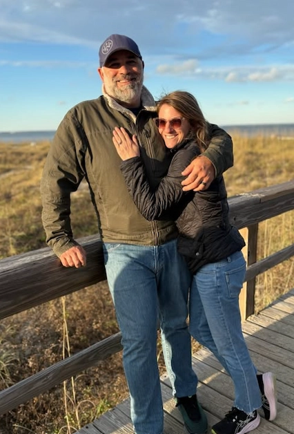 Matt Farah and his wife Hanna standing together on a wooden boardwalk